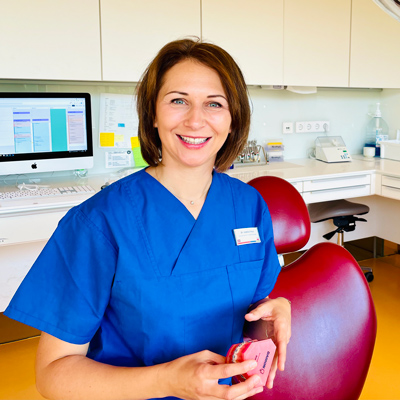 Zahnärztin Dr. Isabella Piekos KU64 im Behandlungszimmer mit Zahnmodell