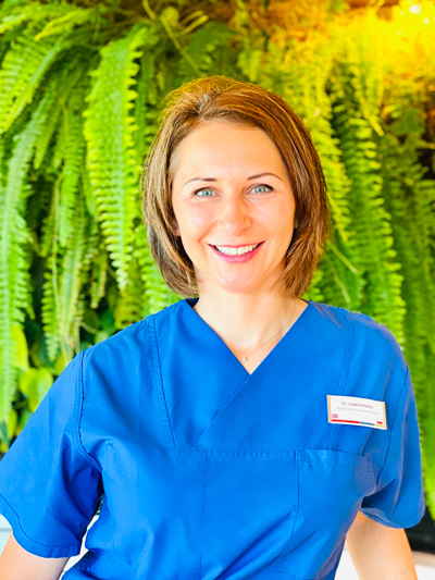 Zahnärztin Dr. Isabella Piekos vor den Pflanzen im KU64 Empfangsbereich
